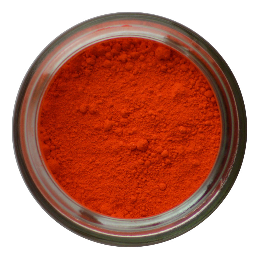 Top view of a glass jar filled with bright orange-red powdered pigment, showing a finely textured surface with some small clumps.