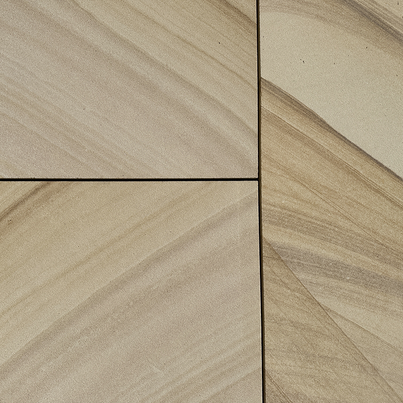 Close-up view of beige and light brown sandstone tiles arranged in a geometric pattern, showing natural streaks and subtle color variations in the stone.