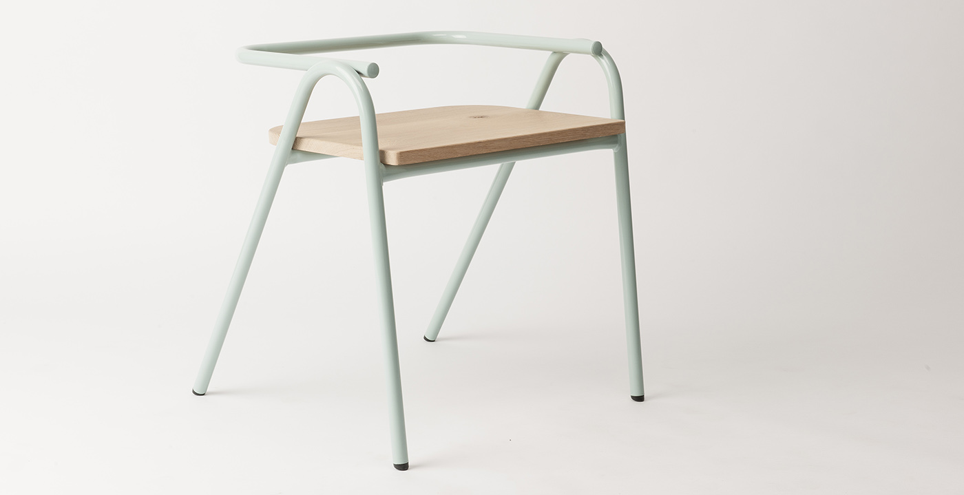 Minimalist chair with a light wood seat and pale green curved metal frame, featuring four angled legs and an open, modern design against a plain white background.